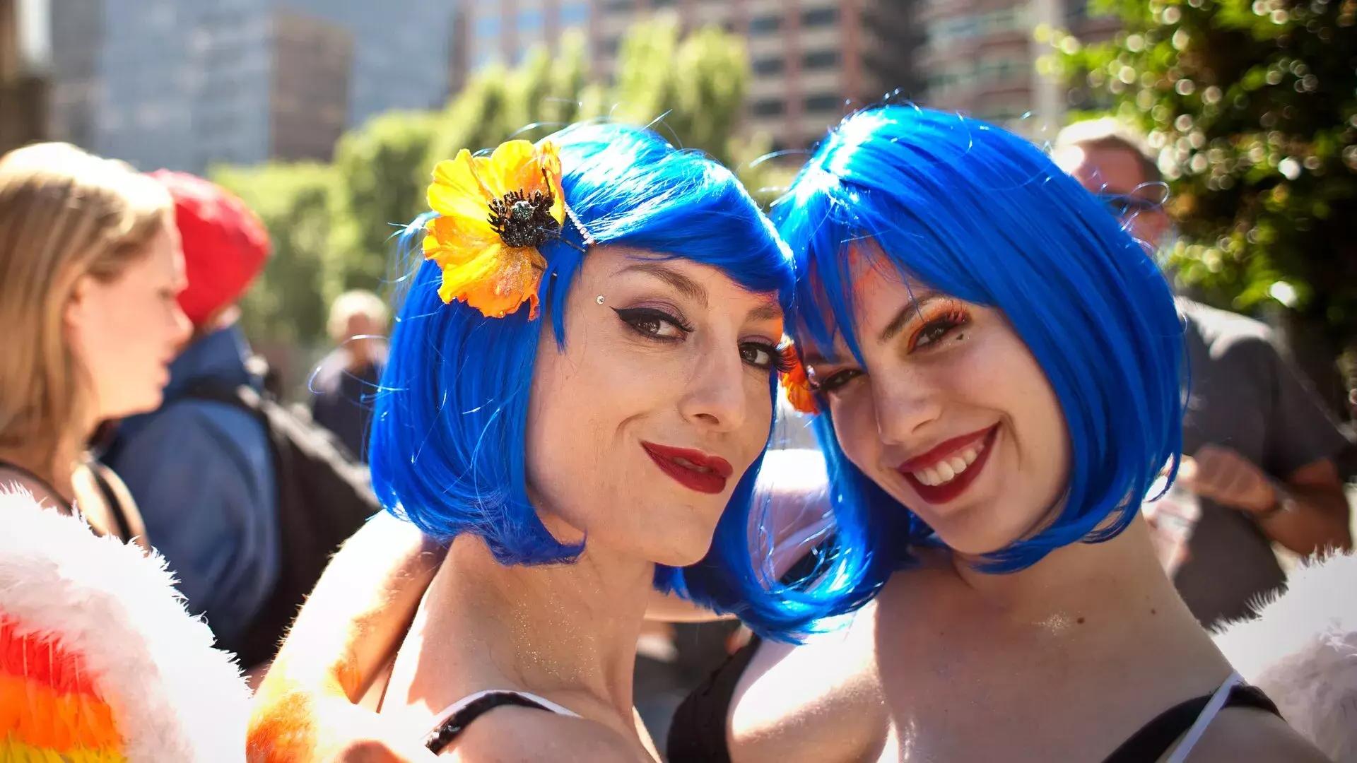 两名戴着蓝色假发的妇女参加贝博体彩app骄傲游行.