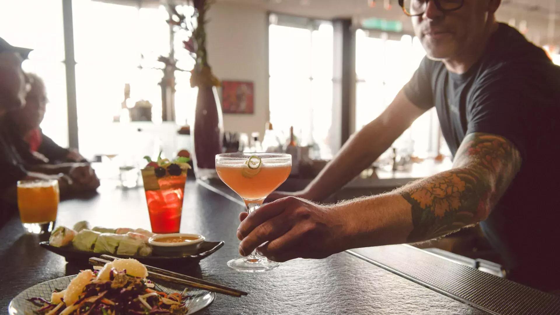 Un barman sirve un cóctel a un cliente en un bar de San Francisco.