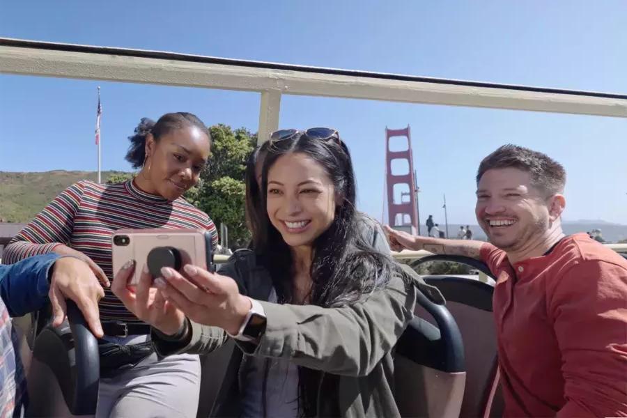 Un grupo de visitantes se toma una selfie en un recorrido en autobús cerca del puente Golden Gate. San Francisco, CA.
